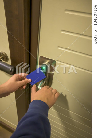 Close-up of a hand using a blue card key on a hotel door lock, key electronic lock, hotel room, holidays in mallorca, spain Close-up of a hand using a blue card key on a hotel door lock, key electronic lock, hotel room, holidays in mallorca, spain 134207156