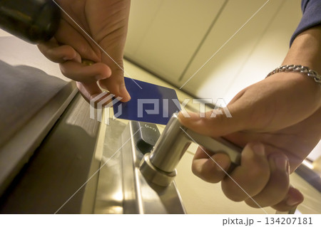 A hand inserting a blue card key into a modern hotel door lock, key electronic lock, hotel room, holidays in mallorca, spain 134207181