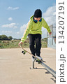 young, teenager, with a skateboard, jumping, on a track, skateboarding, wearing headphones 134207191