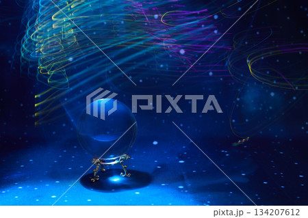 Mystical Crystal Sphere. A crystal ball under swirling colorful light streaks and a starry backdrop. Mystical Crystal Sphere. A crystal ball under swirling colorful light streaks and a starry backdrop. 134207612