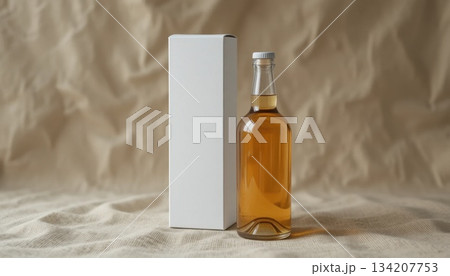 Elegant Glass Bottle Filled With Amber Liquid Beside a Plain White Box on a Textured Surface 134207753