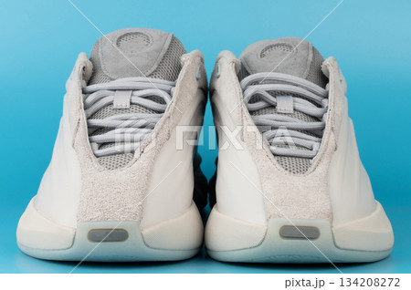 Sneakers displayed on a blue background for product viewing Sneakers displayed on a blue background for product viewing 134208272
