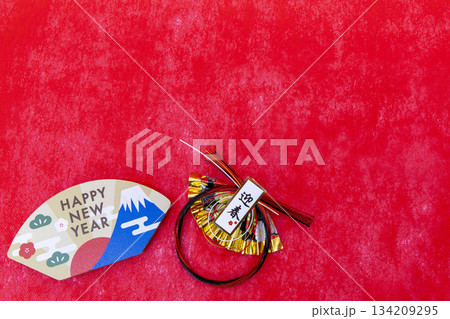 赤背景に置かれた「HAPPY NEW YEAR」の扇飾りと水引のお正月イメージ 134209295