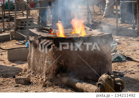 A burning furnace in local foundry of Thailand. Steel production in manual furnace. A burning furnace in local foundry of Thailand. Steel production in manual furnace. 134211492