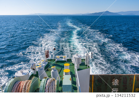 フェリーの船尾から見る、青い海に残る長く白い航跡 134211532
