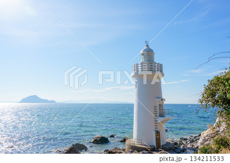 青空と海を背景に立つ伊良湖岬灯台、沖に神島 134211533