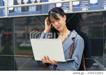 Woman person on street, business work lifestyle outdoors, travel, experiencing stressful headache while holding laptop, feeling unwell in urban city environment, requiring break. 134212001