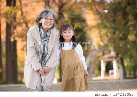 紅葉の秋の公園で遊ぶおばあちゃんと寄り添う孫娘 カメラ目線 紅葉の秋の公園で遊ぶおばあちゃんと寄り添う孫娘 カメラ目線 134212053