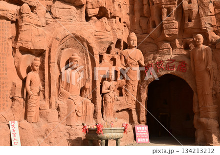 Buddha statue sculpture on the cliff face of the temple in front of the entrance gate at the Tianshan Grand Canyon, or Kesileya Grand Canyon, is a stunning natural feature in Xinjiang, China,  134213212