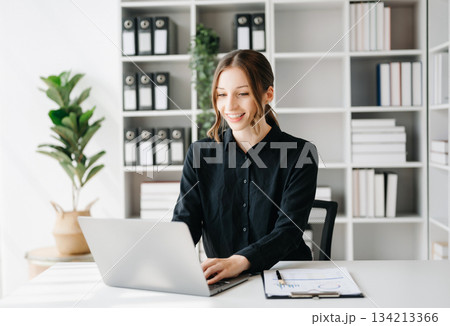 Business woman using tablet and laptop for doing math finance on an office 134213366