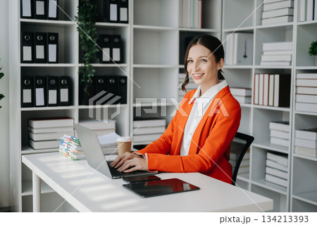 Business woman using tablet and laptop for doing math finance on an office 134213393