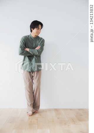 壁に寄りかかって立っている男性 壁に寄りかかって立っている男性 134213832