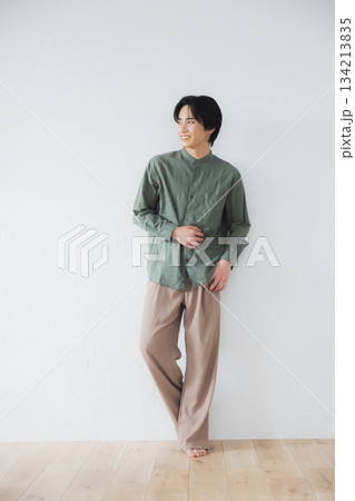 壁に寄りかかって立っている男性 134213835