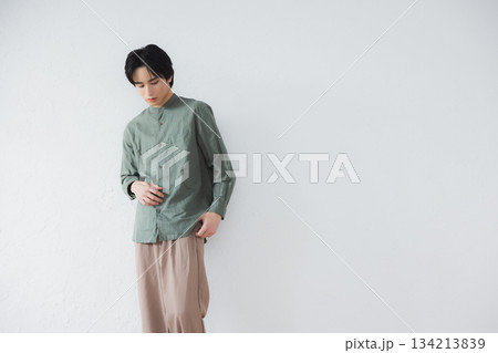 壁に寄りかかって立っている男性 134213839
