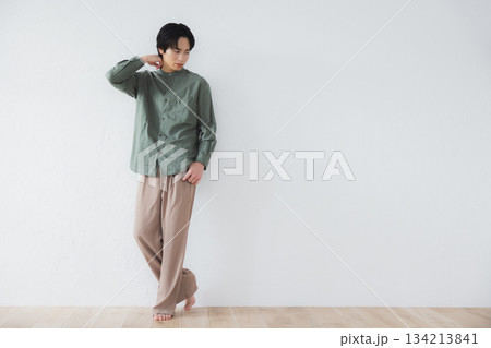 壁に寄りかかって立っている男性 134213841