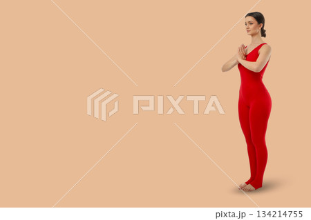Yoga session shows a person standing in a form position Yoga session shows a person standing in a form position 134214755