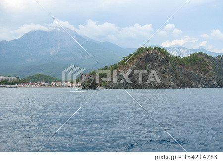 Rocky coast and sea cave on azure water clear day horizontal 134214783