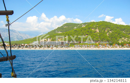 Beach resort by mountains on turquoise sea view from water horizontal Beach resort by mountains on turquoise sea view from water horizontal 134214811