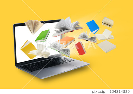 Books are flying around a laptop on a bright yellow backdrop Books are flying around a laptop on a bright yellow backdrop 134214829