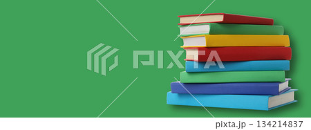 Colorful books stacked on green backdrop for study or mockup 134214837