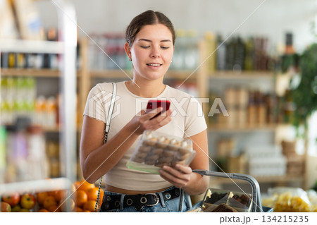 Young woman scanning qr code of champignons Young woman scanning qr code of champignons 134215235