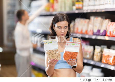 Adult woman chooses healthy food in store 134215266