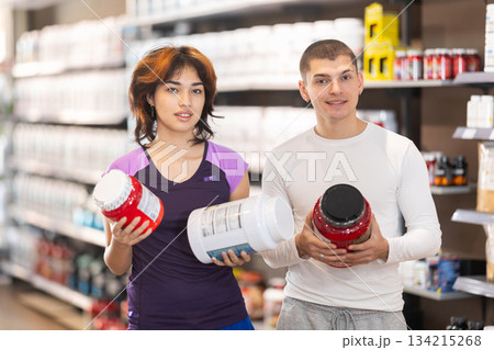 Guy and Latin girl consult about purchasing sports nutrition, enriched protein shake Guy and Latin girl consult about purchasing sports nutrition, enriched protein shake 134215268