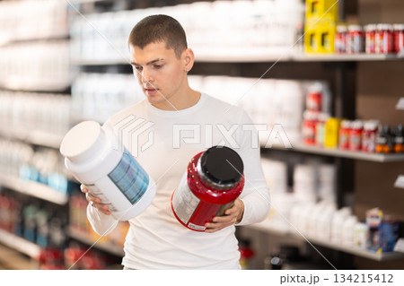 Guy chooses protein sports nutrition in store Guy chooses protein sports nutrition in store 134215412