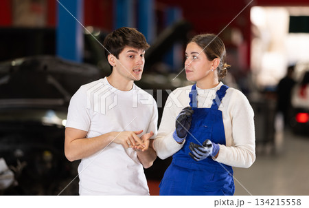 guy consults with a car service worker 134215558