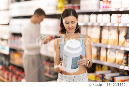 Adult woman buying jar of sports nutrition Adult woman buying jar of sports nutrition 134215562
