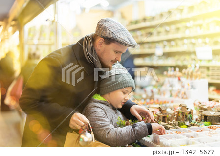 Father and son choose figures for the nativity scene Father and son choose figures for the nativity scene 134215677
