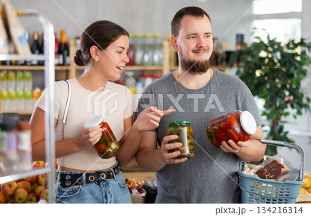 Couple man and woman choosing pickled cucumbers and tomatoes Couple man and woman choosing pickled cucumbers and tomatoes 134216314