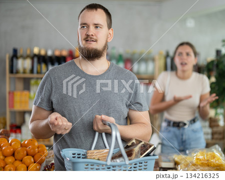 Young woman quarrels with man in grocery store 134216325