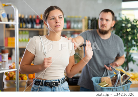 Husband calms his wife down after an argument in grocery supermarket, apologizing 134216326