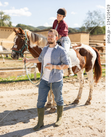 Horseback riding during a tour of horse farm 134216419