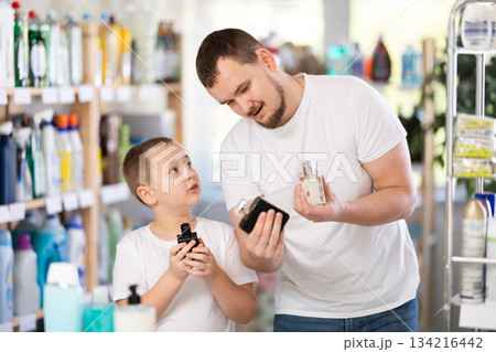 Young man and boy choosing perfume in store Young man and boy choosing perfume in store 134216442