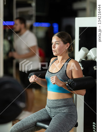 Woman training her hands in the machine 134216444