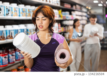 Latin girl chooses protein sports nutrition in store Latin girl chooses protein sports nutrition in store 134216504