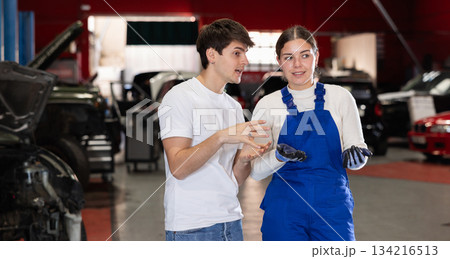 guy consults with a car service worker guy consults with a car service worker 134216513