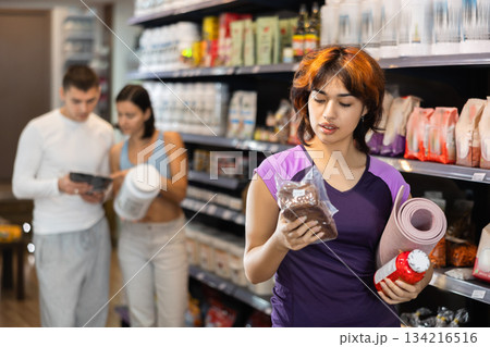 Young woman chooses healthy bread and sports nutrition Young woman chooses healthy bread and sports nutrition 134216516