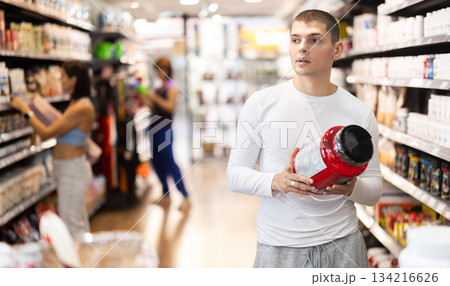 Guy chooses protein sports nutrition in store Guy chooses protein sports nutrition in store 134216626