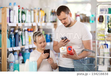 Dad and son scan barcode on packaging of sewer cleaner liquid 134216638