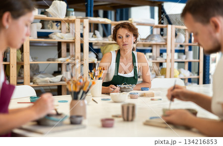 Three craftsperson are busy painting clay products 134216853