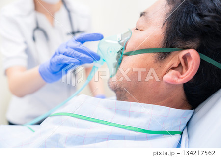 人工呼吸器をつけた患者のケアをする看護師の女性 人工呼吸器をつけた患者のケアをする看護師の女性 134217562