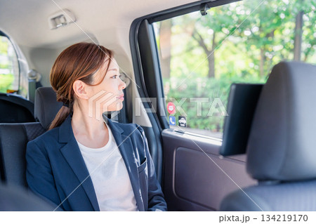 タクシーの後部座席に座るキャリアウーマン 134219170