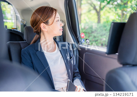 タクシーの後部座席に座るキャリアウーマン 134219171