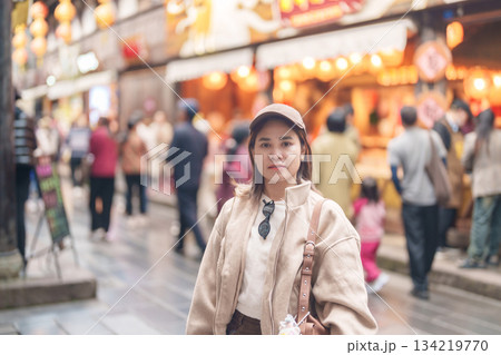 Happy woman traveler travel in Chengdu city. Tourist sightseeing and shopping in Jinli Ancient Street. Famous Landmark for tourism attraction in Sichuan, China Happy woman traveler travel in Chengdu city. Tourist sightseeing and shopping in Jinli Ancient Street. Famous Landmark for tourism attraction in Sichuan, China 134219770