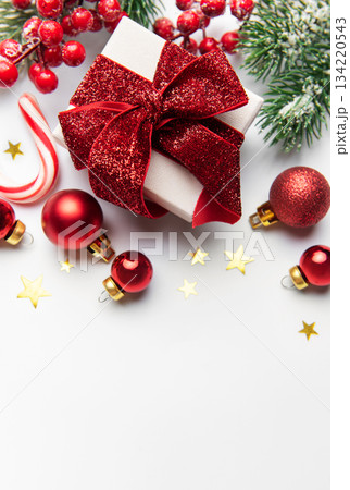 Christmas gift with red ornaments and pine branches Christmas gift with red ornaments and pine branches 134220543