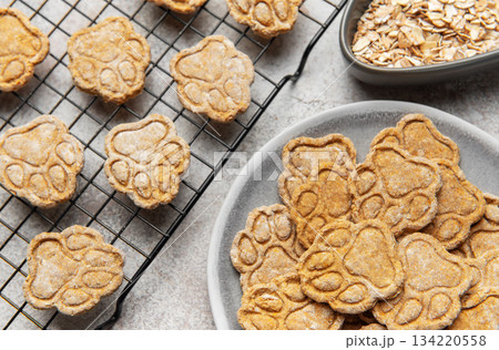 Homemade paw print dog treats cooling on rack 134220558