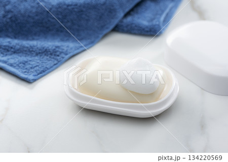 泡の乗った固形石けんとタオルが並ぶ清潔感あふれるバスルームイメージ 134220569